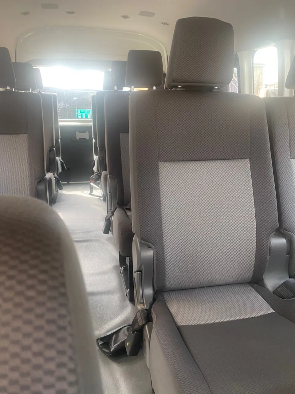 Toyota Hiace interior aisle with rows of passenger seats